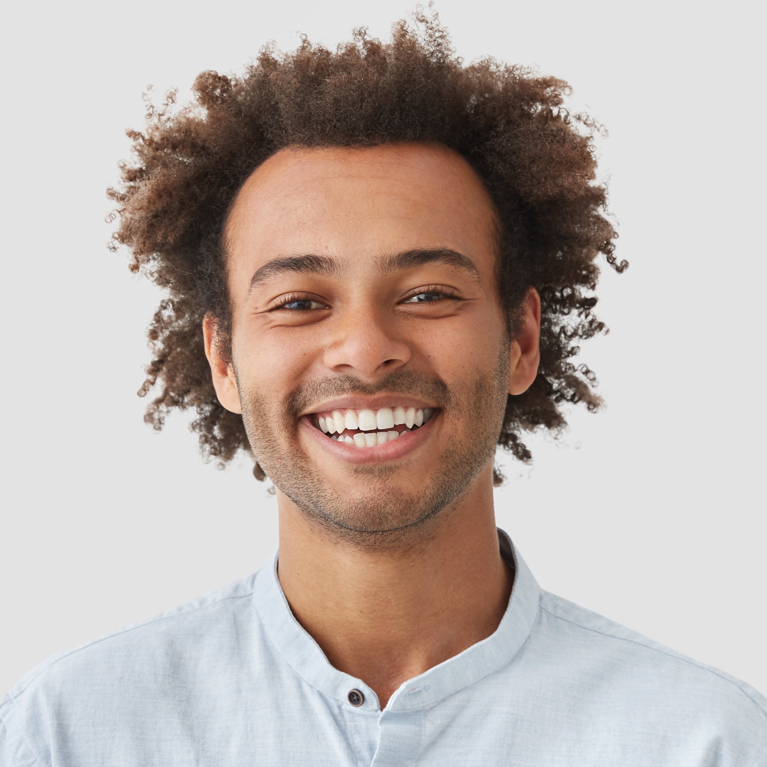 happy-man-student-with-afro-hairdo-shows-white-teeth-being-good-mood-after-classes